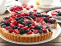 Pyszna tarta z mascarpone, udekorowana świeżymi malinami, borówkami i jeżynami. Idealna na letnie popołudnie.