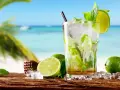 Orzeźwiający koktajl mojito z limonką i miętą na tle plaży. Idealny przepis na lato.