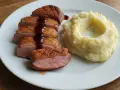 Pokrojona, soczysta pierś z kaczki z chrupiącą skórką, polana sosem, obok porcja purée ziemniaczanego. Idealny sposób, jak zrobić miękką pierś z kaczki.