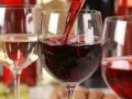 Czerwone wino leje się do kieliszka, obok stoi kieliszek białego wina. To może być najdroższe wino na świecie.