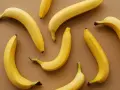 Kilka żółtych bananów ułożonych na brązowym tle. Czy banany można trzymać w lodówce?