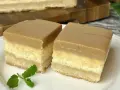 Dwa kawałki sernika z karmelem na białym talerzu, ozdobione listkiem mięty.