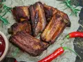 Soczyste żeberka w coli, pieczone do perfekcji, podane z sosem i papryczkami chili. Idealne na grilla lub obiad.