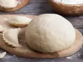 Gotowe ciasto na pierogi i kilka uformowanych pierożków na desce. Czy ciasto na pierogi można zrobić dzień wcześniej? Tak, można!