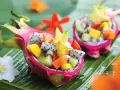 Smoczy owoc w formie miseczki wypełnionej egzotycznymi owocami: kiwi, mango, papają i karambolą.