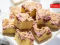Pyszne ciasto ze śliwkami, posypane kruszonką, na talerzu obok filiżanki kawy. Idealne na deser.