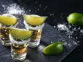 Szklanki z tequilą, ozdobione solą i ćwiartkami limonki. Idealne do picia z limonką, gdy zastanawiasz się, z czym pić tequilę.
