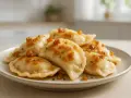 Talerz pełen pysznych, domowych pierogów z serem, polanych skwarkami i szczypiorkiem. Smak dzieciństwa, jak u babci.