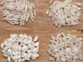 Cztery rodzaje ryżu, w tym ryż do risotto, ułożone na drewnianym tle.