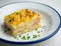 Pyszna warstwowa zapiekanka ziemniaczana z szynką i serem, idealna na obiad. Oto prosty lasagne przepis!
