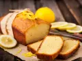 Wilgotna babka piaskowa z cytryną, ozdobiona skórką, podana z plasterkami cytryny.