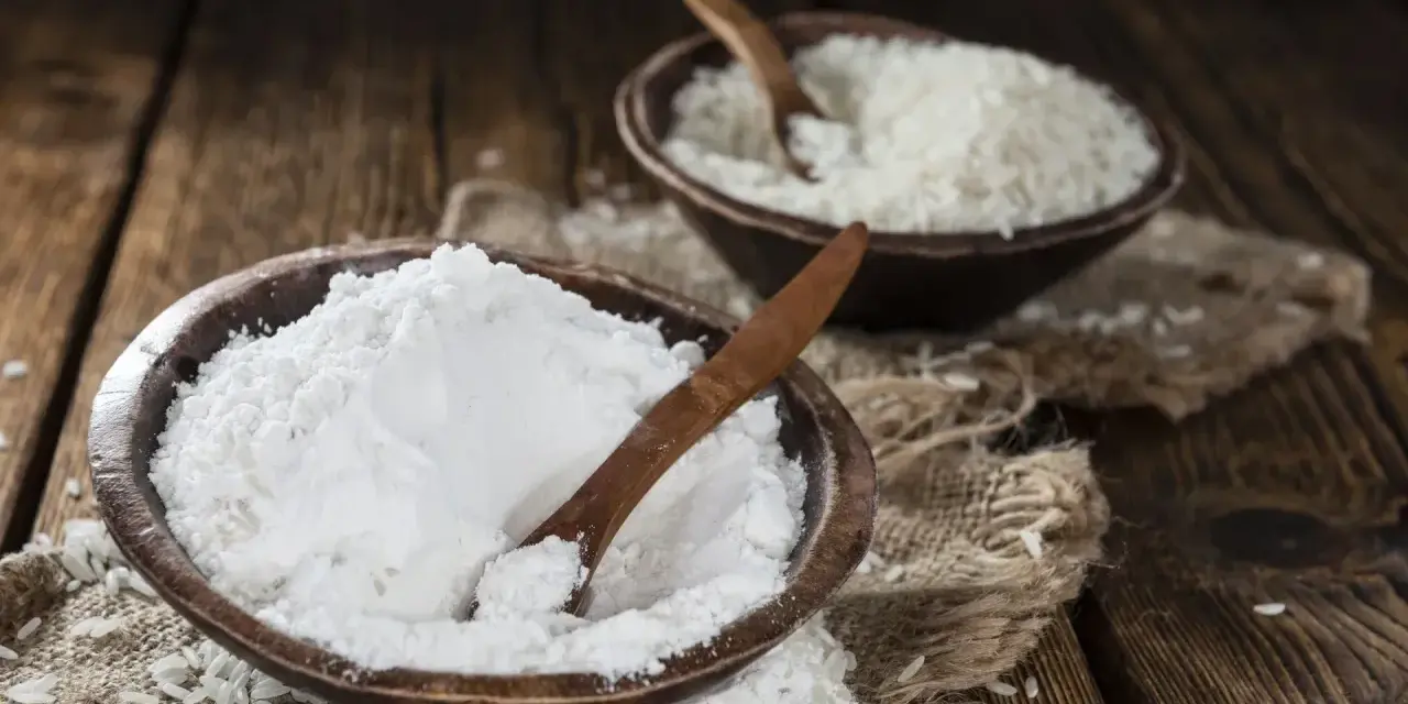 Mąka ryżowa, w przeciwieństwie do pszennej, nie zawiera glutenu. Na zdjęciu widać ją obok ziaren ryżu.