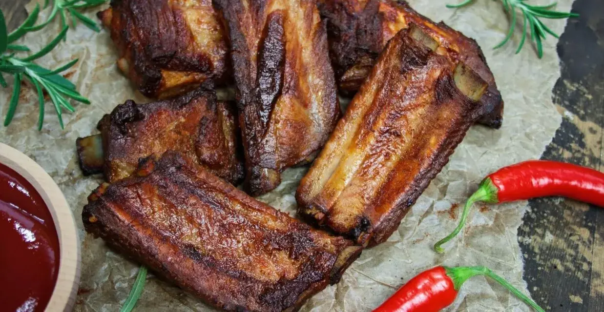 Soczyste żeberka w coli, pieczone do perfekcji, podane z sosem i papryczkami chili. Idealne na grilla lub obiad.