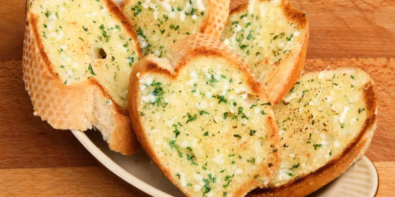 Chrupiące grzanki z piekarnika, posypane czosnkiem i natką pietruszki, kuszą aromatem. Idealne jako dodatek do zupy lub samodzielna przekąska.