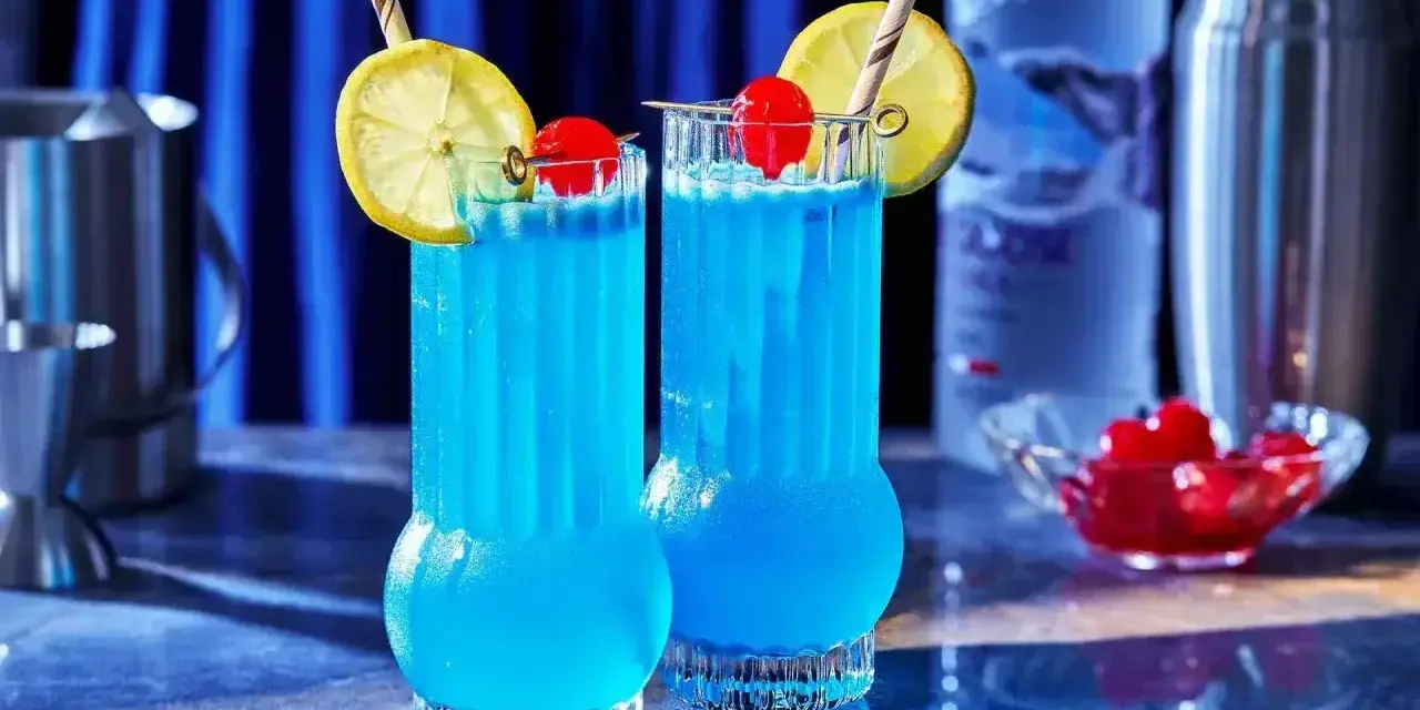 Dwa orzeźwiające drinki Blue Lagoon z cytryną i wiśnią, gotowe do podania.