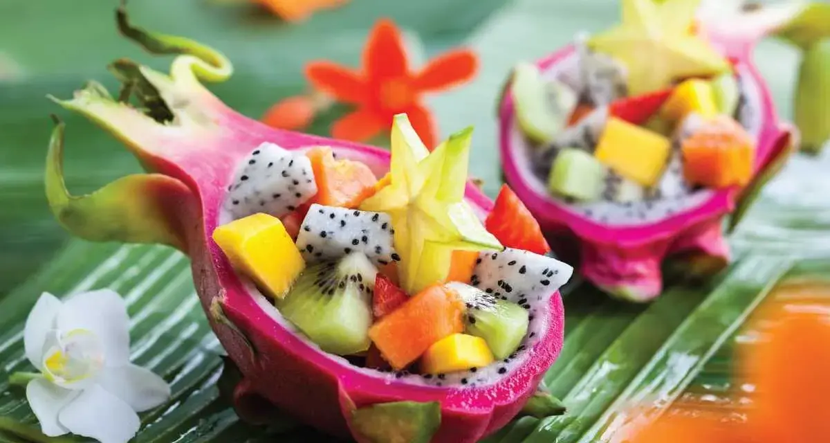 Smoczy owoc w formie miseczki wypełnionej egzotycznymi owocami: kiwi, mango, papają i karambolą.