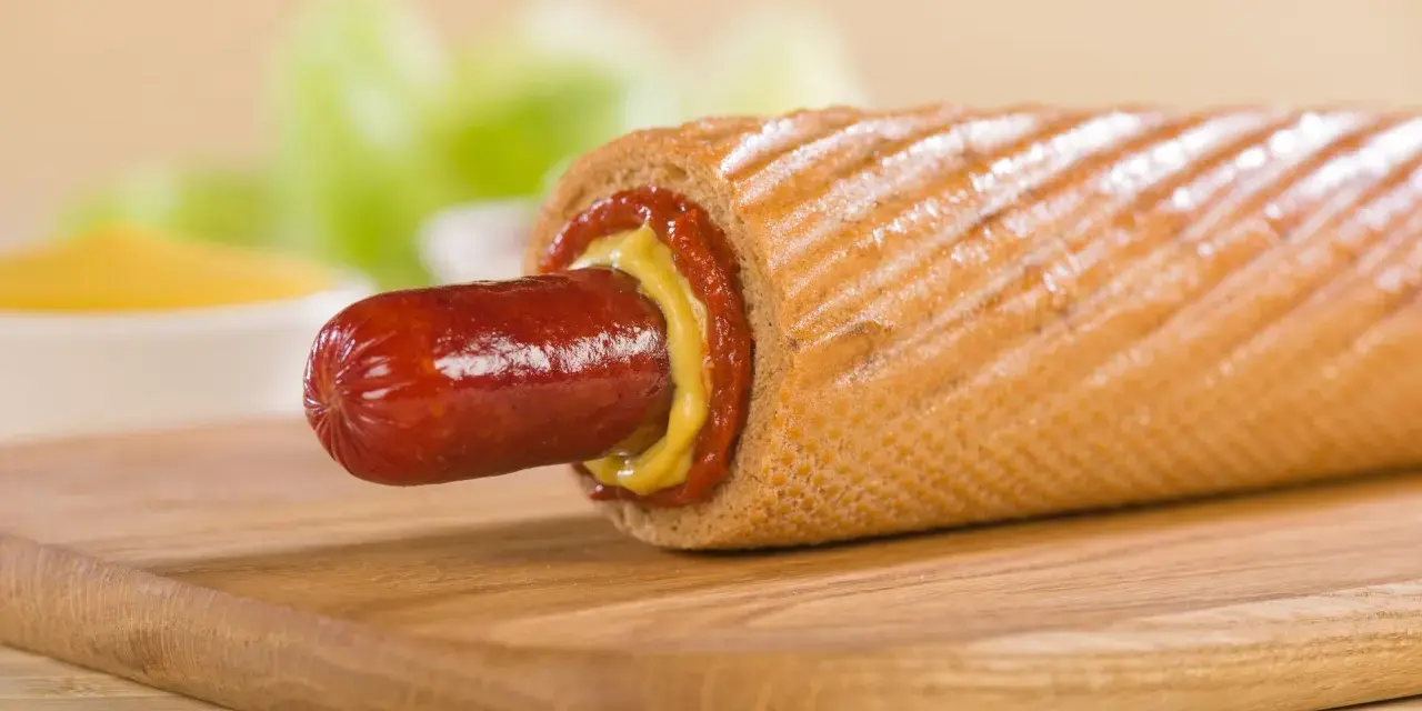Pyszne hot dogi domowe z musztardą i ketchupem na desce.