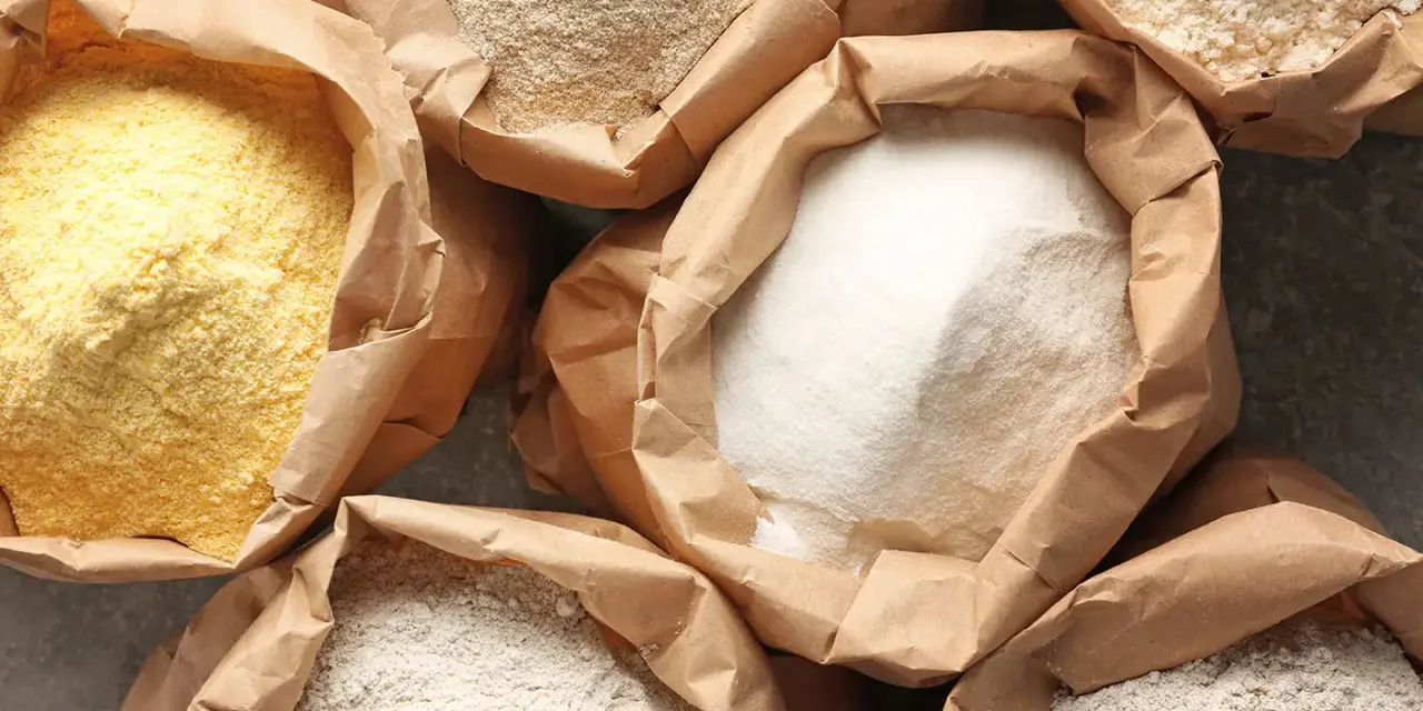 Różne rodzaje mąki w papierowych torbach. Czy mąka żytnia ma gluten? Tak, zawiera go, podobnie jak pszenna.