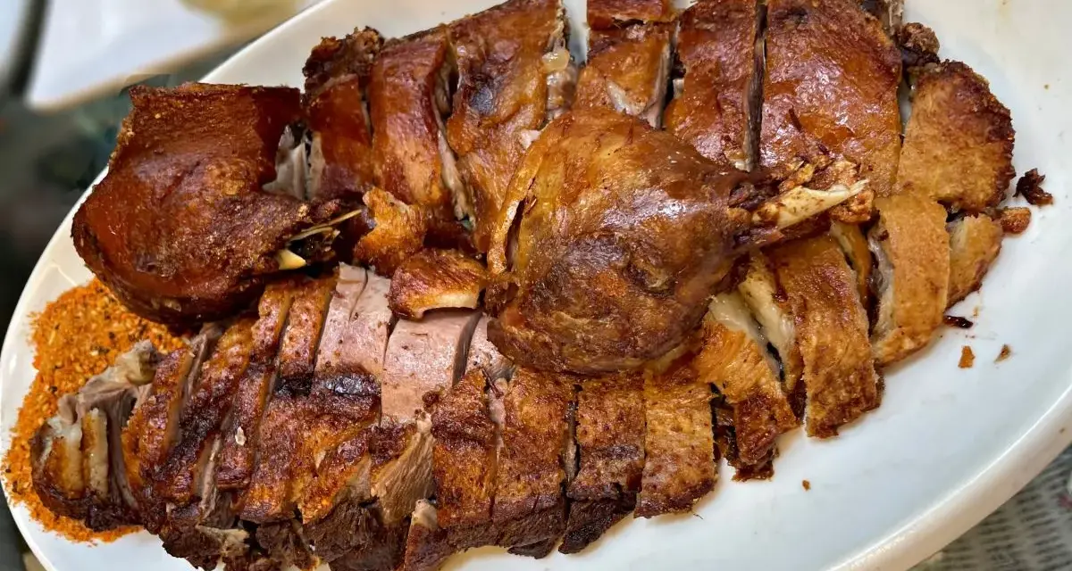 Chrupiąca pieczona gęś, pokrojona na kawałki, z przyprawami. Idealna odpowiedź na pytanie, co zrobić z gęsią na obiad.