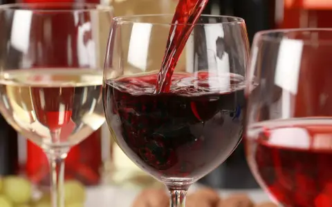 Czerwone wino leje się do kieliszka, obok stoi kieliszek białego wina. To może być najdroższe wino na świecie.