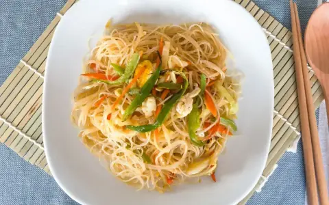 Makaron ryżowy z warzywami na talerzu. Czy makaron ryżowy ma gluten? Nie, jest bezglutenowy.