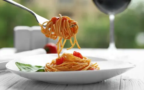 Widok na talerz z makaronem spaghetti i pomidorkami, idealny do rozważań, jakie wino do carbonary.