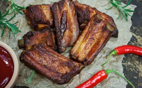 Soczyste żeberka w coli, pieczone do perfekcji, podane z sosem i papryczkami chili. Idealne na grilla lub obiad.