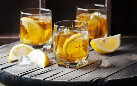 Trzy szklanki z bursztynowym napojem i plasterkami cytryny. Czy to metaxa, co to za drink?