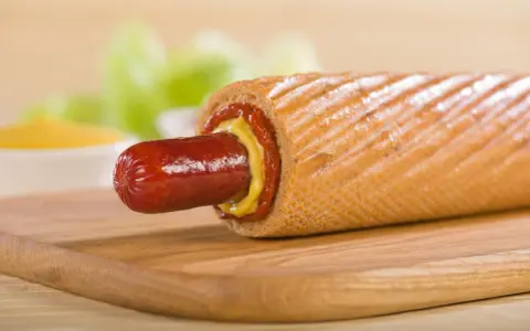 Pyszne hot dogi domowe z musztardą i ketchupem na desce.