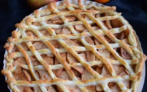 Pyszna tarta z ciasta francuskiego na słodko, wypełniona jabłkami i cynamonem, z kratką z ciasta na wierzchu.