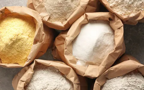 Różne rodzaje mąki w papierowych torbach. Czy mąka żytnia ma gluten? Tak, zawiera go, podobnie jak pszenna.