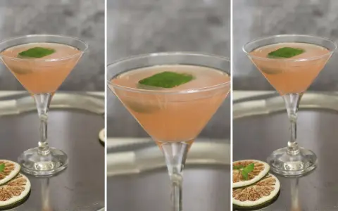 Różowy koktajl w kieliszku, ozdobiony listkiem mięty. Obok suszone plasterki cytrusów. Prawdziwy, stary kubański drink.