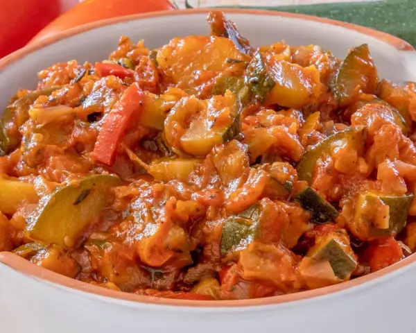 Pyszny bigos z cukinii, pomidorów i papryki, duszony w aromatycznym sosie. Idealny na letni obiad.