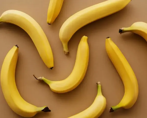 Kilka żółtych bananów ułożonych na brązowym tle. Czy banany można trzymać w lodówce?