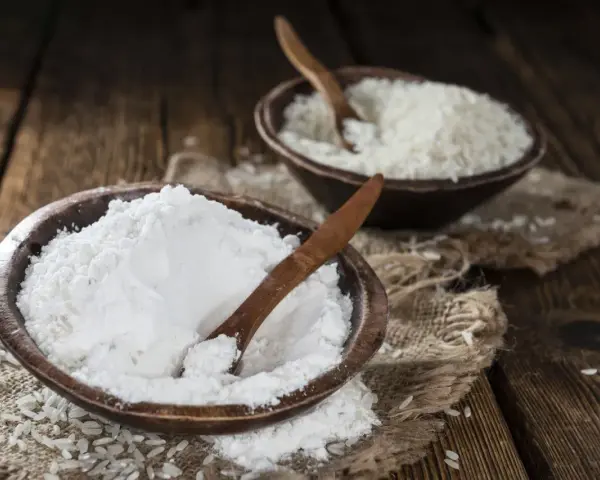 Mąka ryżowa, w przeciwieństwie do pszennej, nie zawiera glutenu. Na zdjęciu widać ją obok ziaren ryżu.