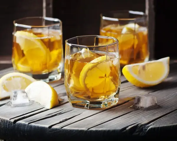 Trzy szklanki z bursztynowym napojem i plasterkami cytryny. Czy to metaxa, co to za drink?