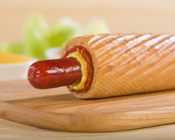 Pyszne hot dogi domowe z musztardą i ketchupem na desce.