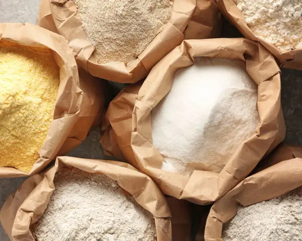 Różne rodzaje mąki w papierowych torbach. Czy mąka żytnia ma gluten? Tak, zawiera go, podobnie jak pszenna.