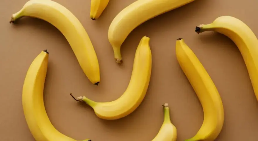 Kilka żółtych bananów ułożonych na brązowym tle. Czy banany można trzymać w lodówce?