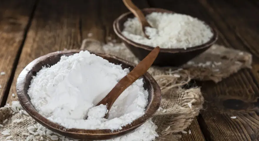 Mąka ryżowa, w przeciwieństwie do pszennej, nie zawiera glutenu. Na zdjęciu widać ją obok ziaren ryżu.