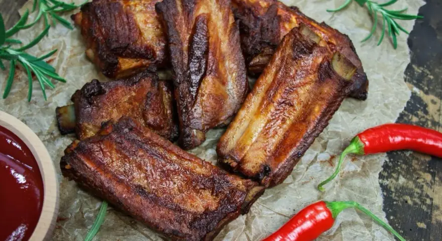 Soczyste żeberka w coli, pieczone do perfekcji, podane z sosem i papryczkami chili. Idealne na grilla lub obiad.