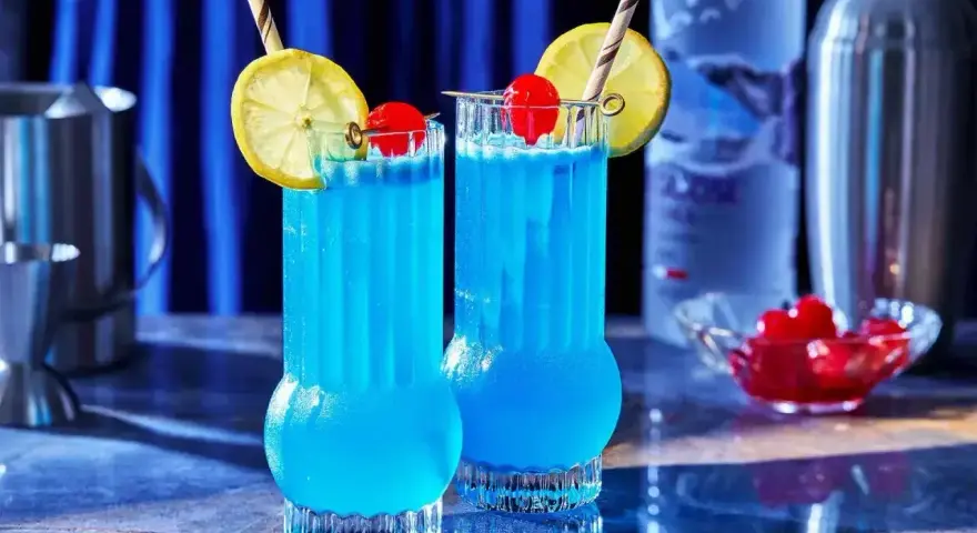 Dwa orzeźwiające drinki Blue Lagoon z cytryną i wiśnią, gotowe do podania.