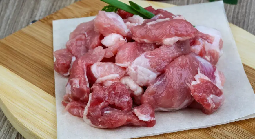 Świeże, pokrojone w kostkę mięso wieprzowe, idealne na aromatyczny gulasz. Wybór, jakie mięso na gulasz, jest kluczowy dla smaku.
