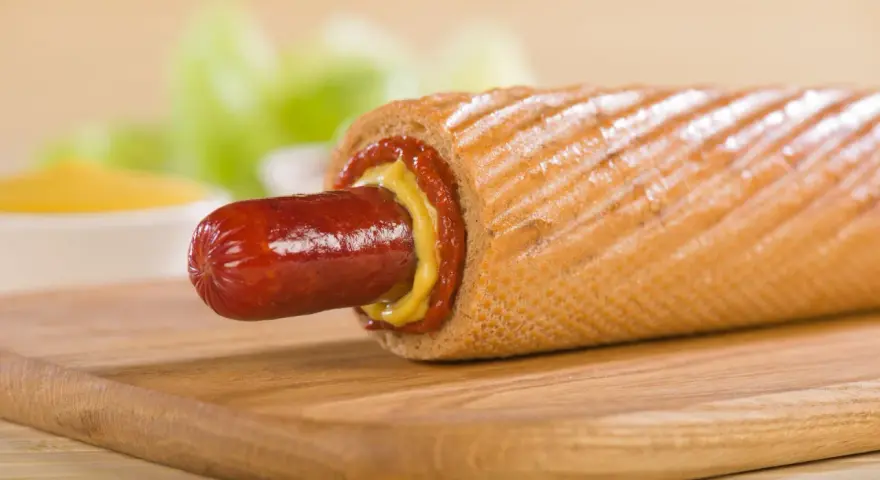 Pyszne hot dogi domowe z musztardą i ketchupem na desce.