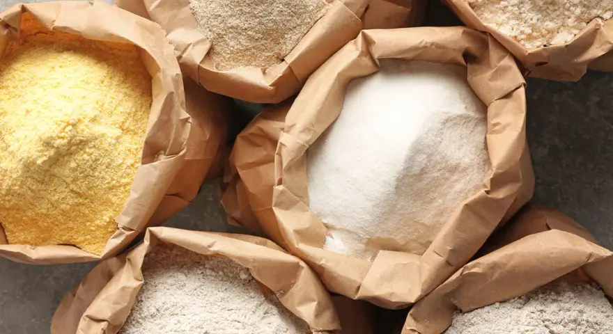 Różne rodzaje mąki w papierowych torbach. Czy mąka żytnia ma gluten? Tak, zawiera go, podobnie jak pszenna.