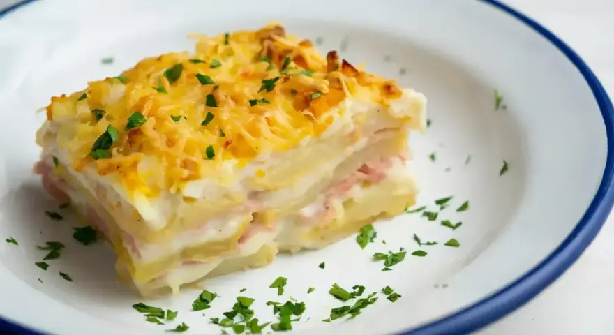 Pyszna warstwowa zapiekanka ziemniaczana z szynką i serem, idealna na obiad. Oto prosty lasagne przepis!