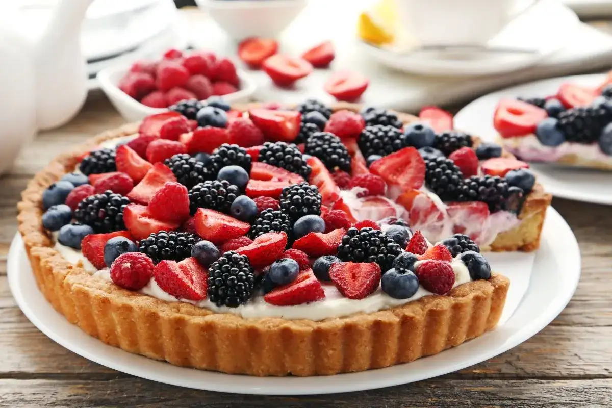 Pyszna tarta z mascarpone, udekorowana świeżymi malinami, bor&oacute;wkami i truskawkami. Idealna na letnie popołudnie.