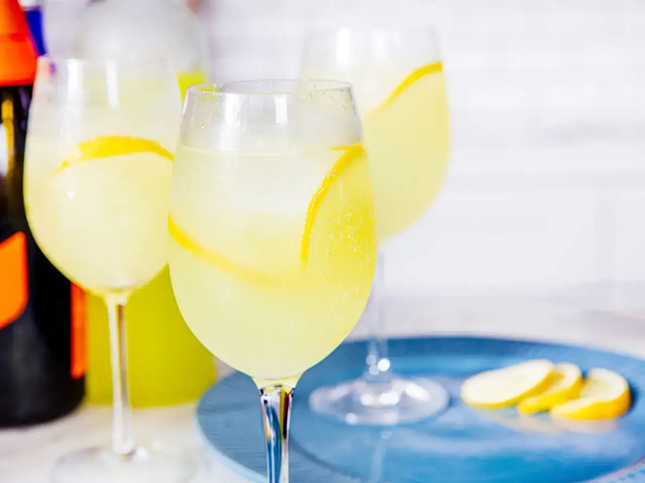 Orzeźwiający limoncello spritz z plasterkami cytryny, podany w kieliszkach z lodem. Idealny na letnie popołudnie.