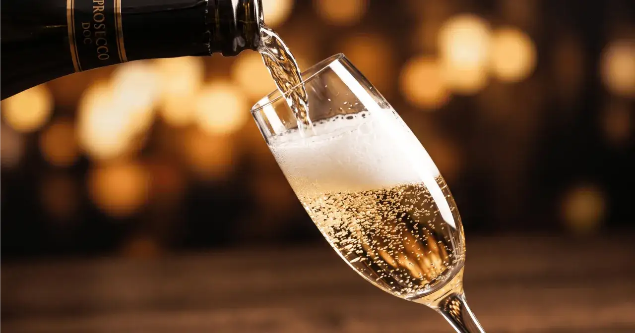 Bąbelki musującego prosecco wypełniają kieliszek, gdy jest nalewane z butelki. To jest właśnie prosecco!
