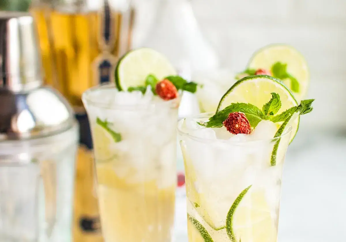 Orzeźwiający, old cuban drink z limonką, miętą i truskawką, przygotowany w szklance z lodem.